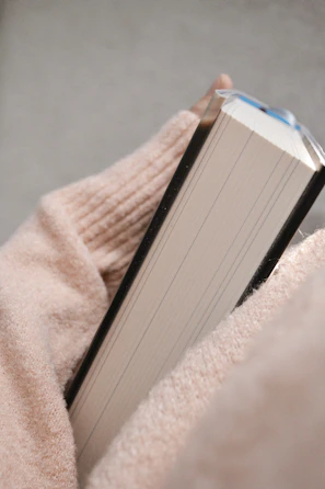 Close-up of a hand holding the book with a cozy background.