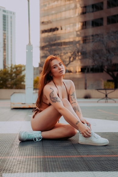 a woman sitting on the ground with her legs crossed