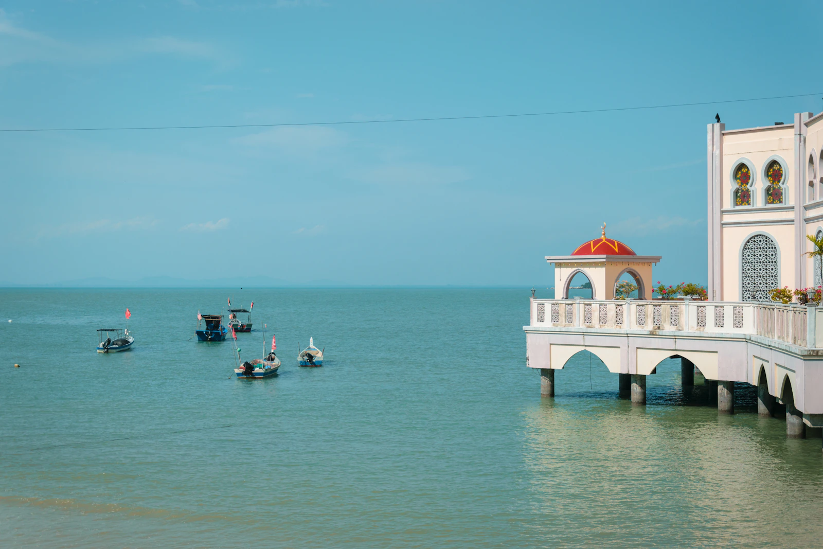 Boats off the coast beside a waterfront building in George Town, Penang