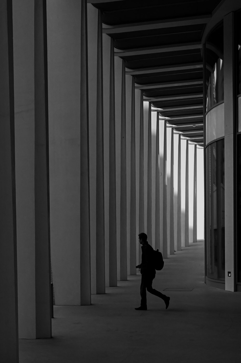 a person walking down a hallway with a backpack