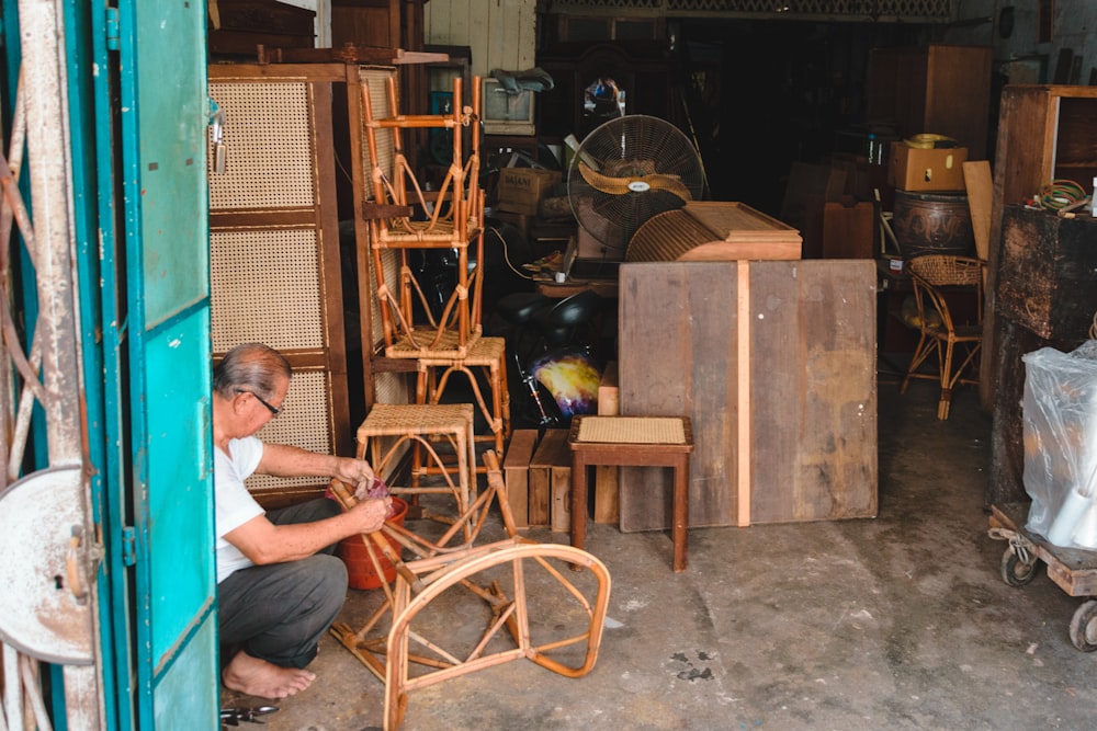 a man working on a chair in a shop