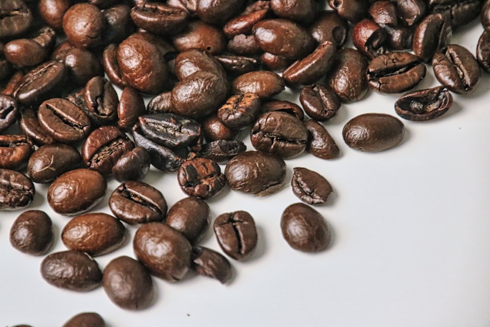 a pile of coffee beans sitting on top of a white plate