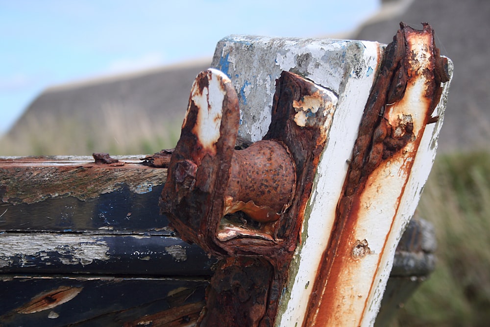 a rusted metal object with a building in the background