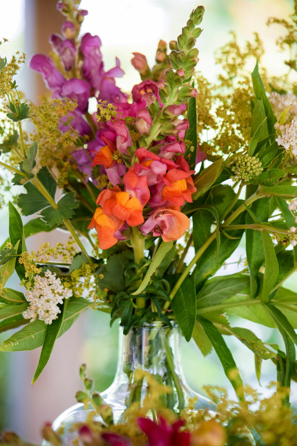 a vase filled with lots of different colored flowers