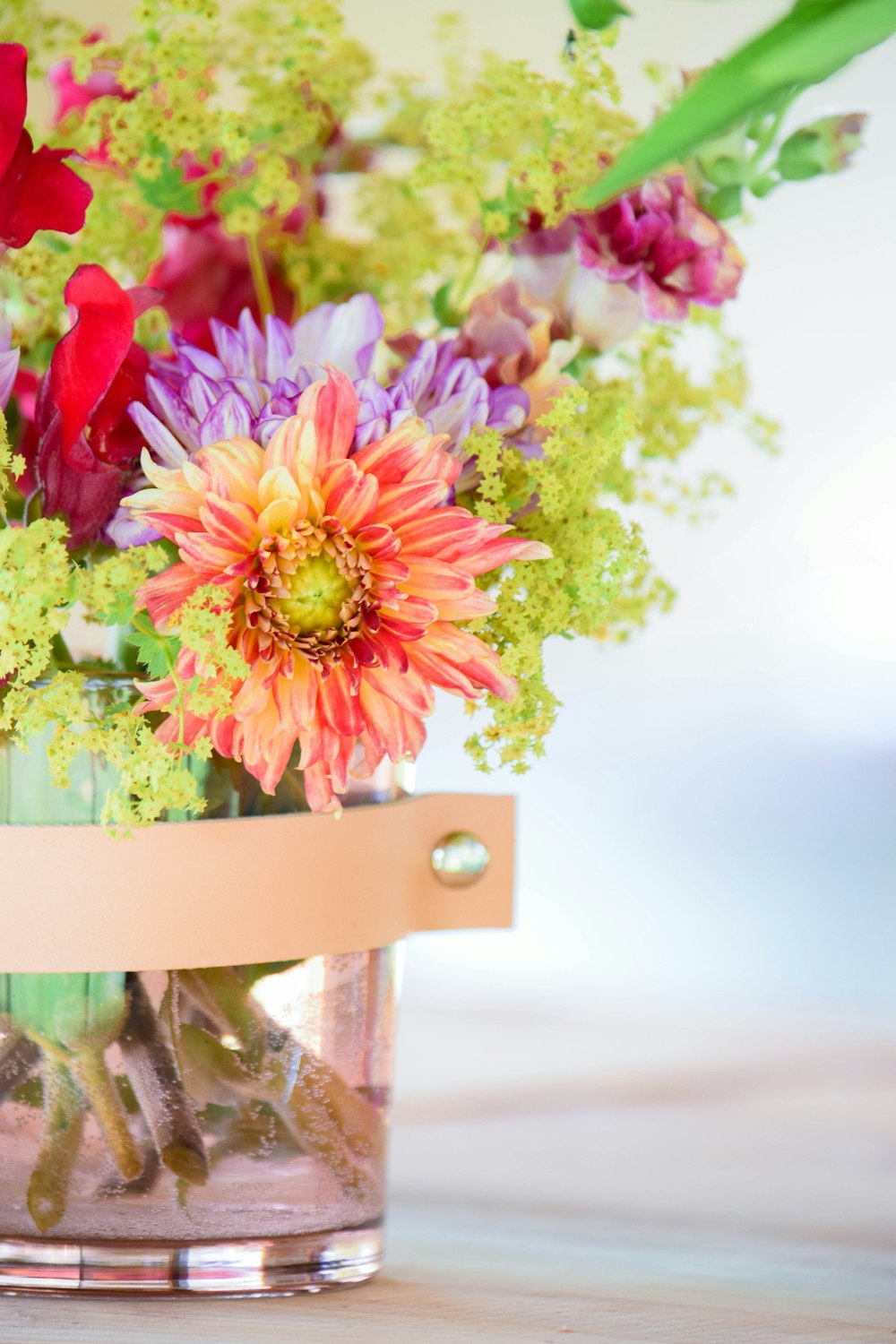 a vase filled with lots of flowers on top of a table