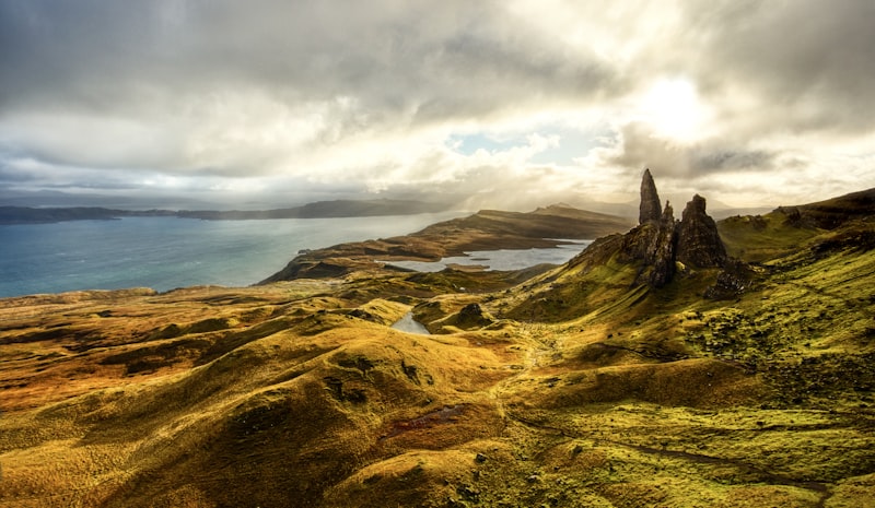 The Old Man of Storr pinnacle rising from moorland above the Sound of Raasay under dramatic clouds