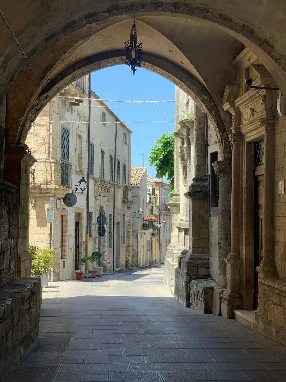 an archway leading to a building with a clock on it