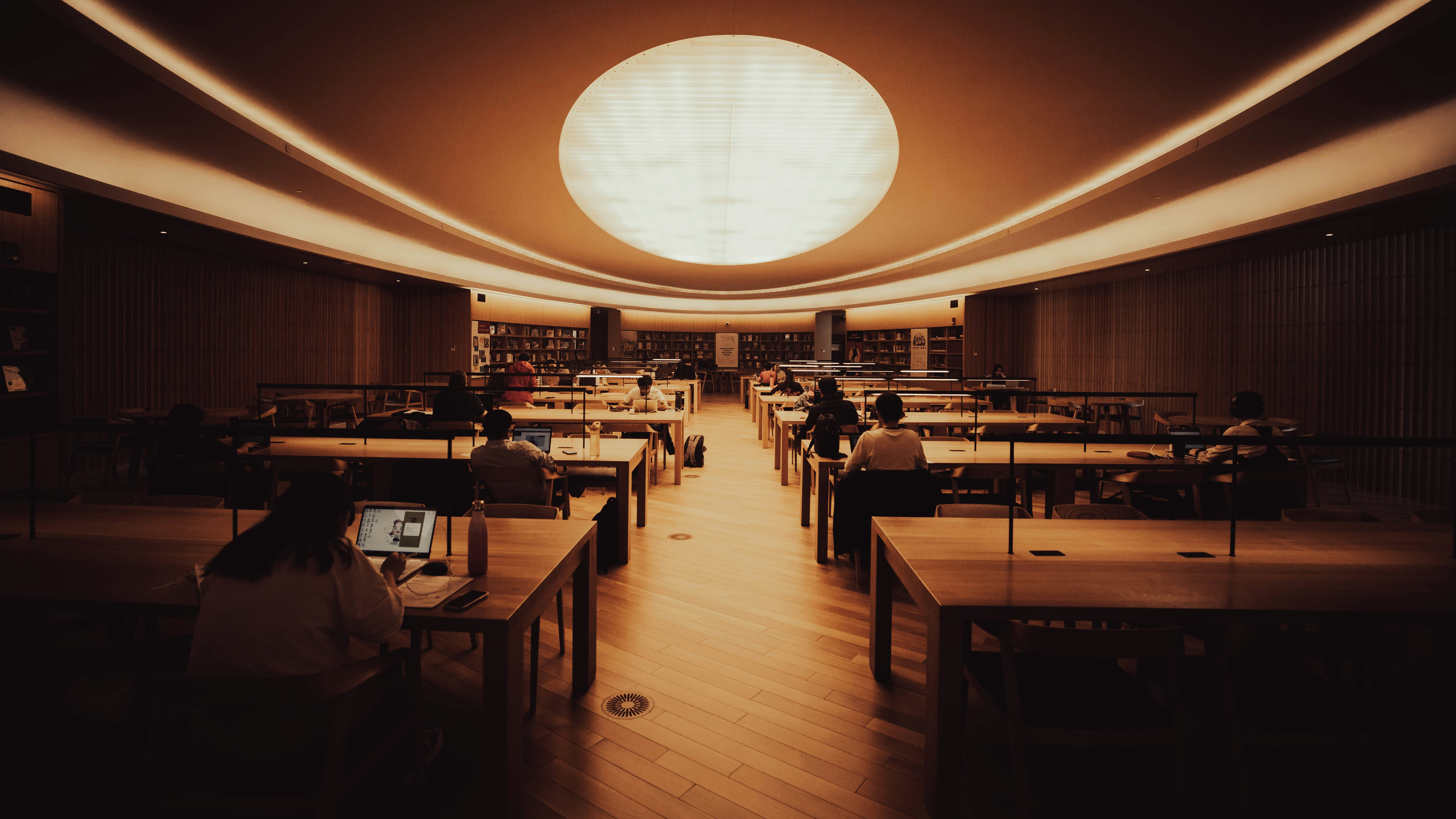 a group of people sitting at desks in a library