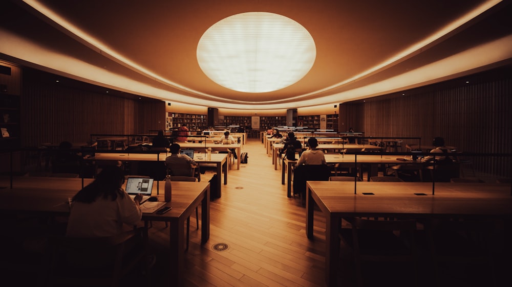 a group of people sitting at desks in a library