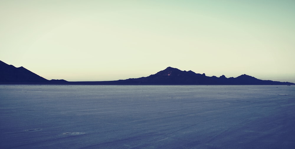 a large body of water with mountains in the background