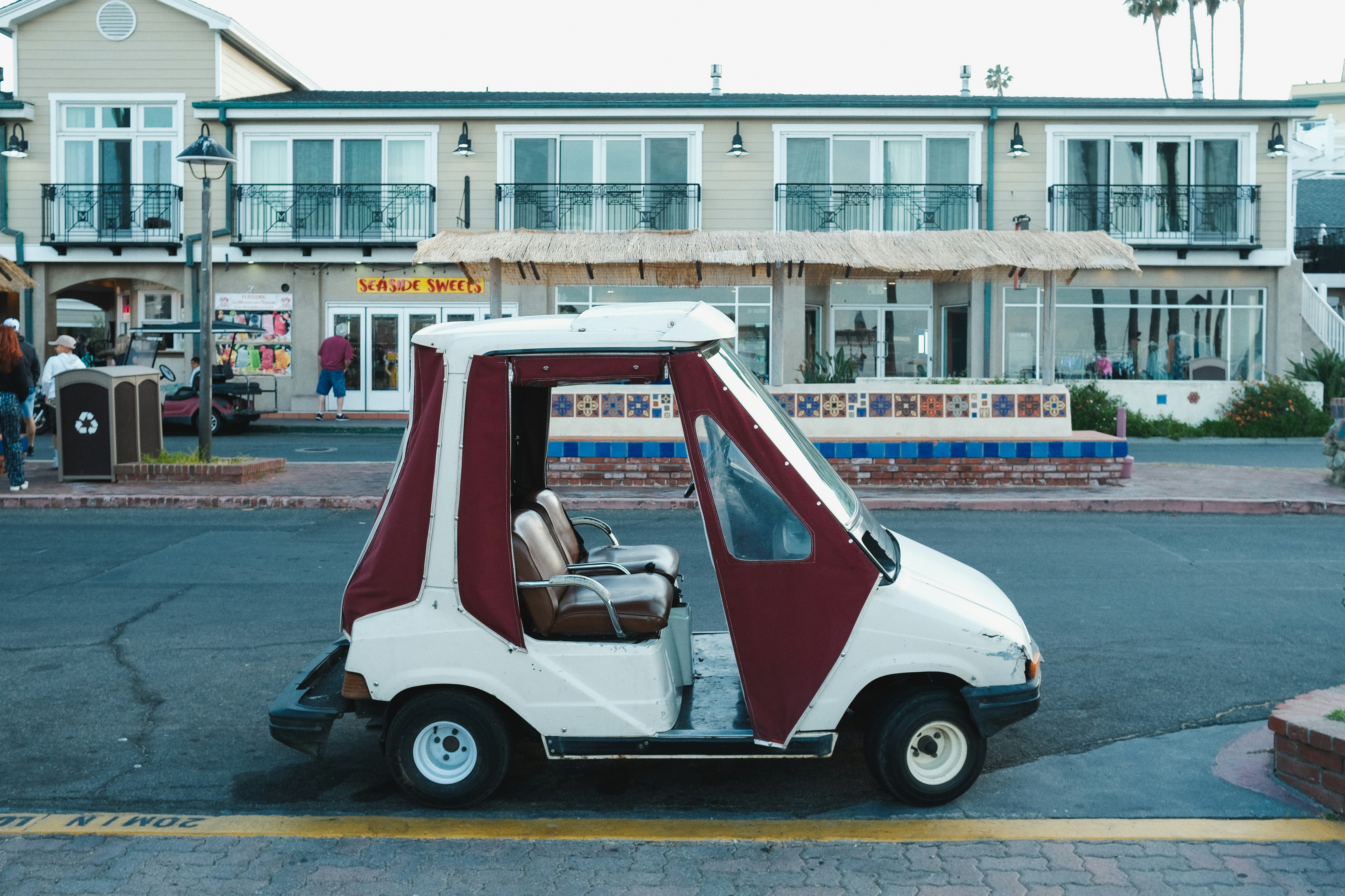 a small white and red car parked in front of a hotel