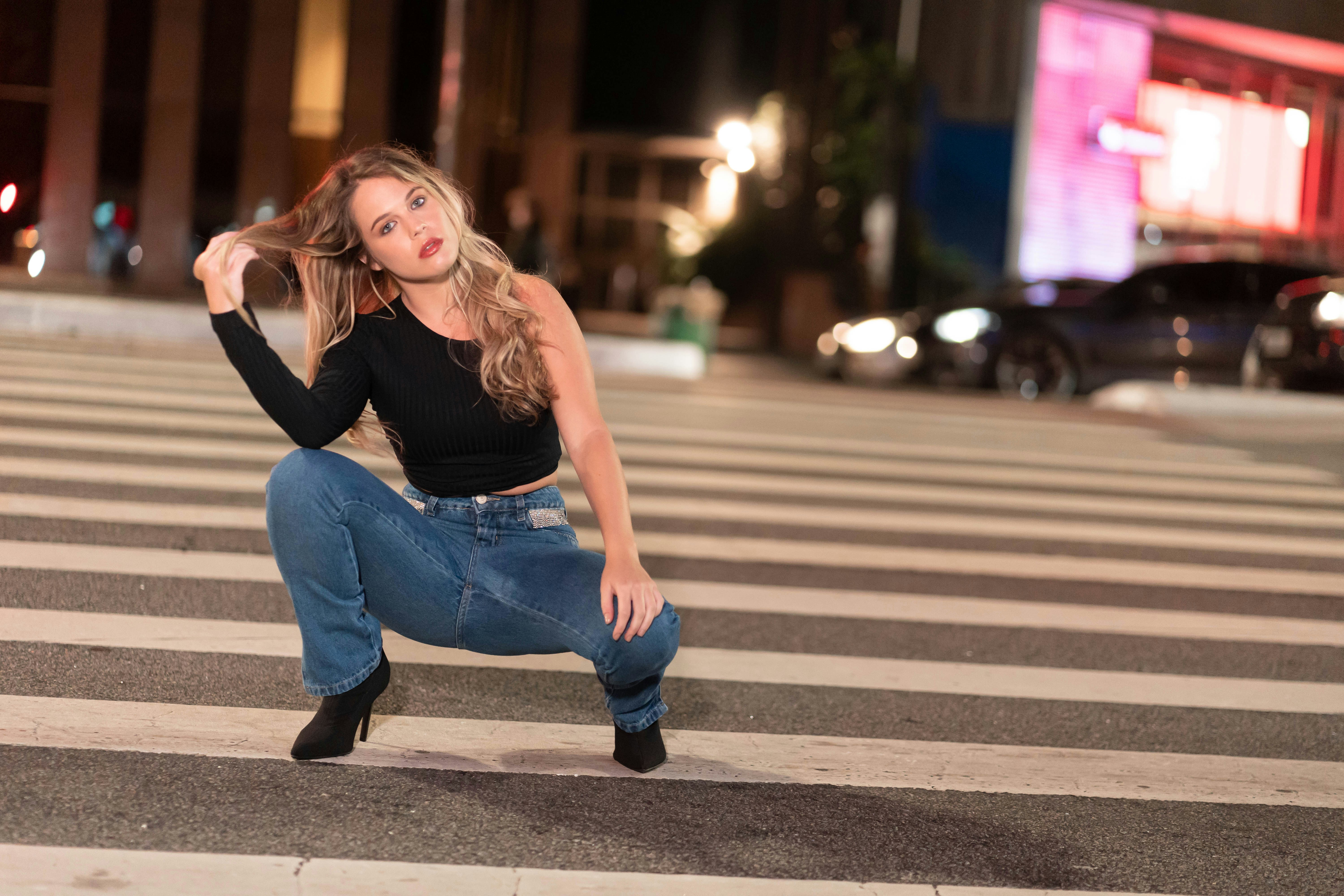 a woman kneeling down on a cross walk