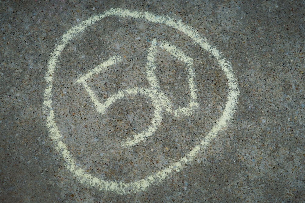 a close up of a cement surface with the number 50 written in it