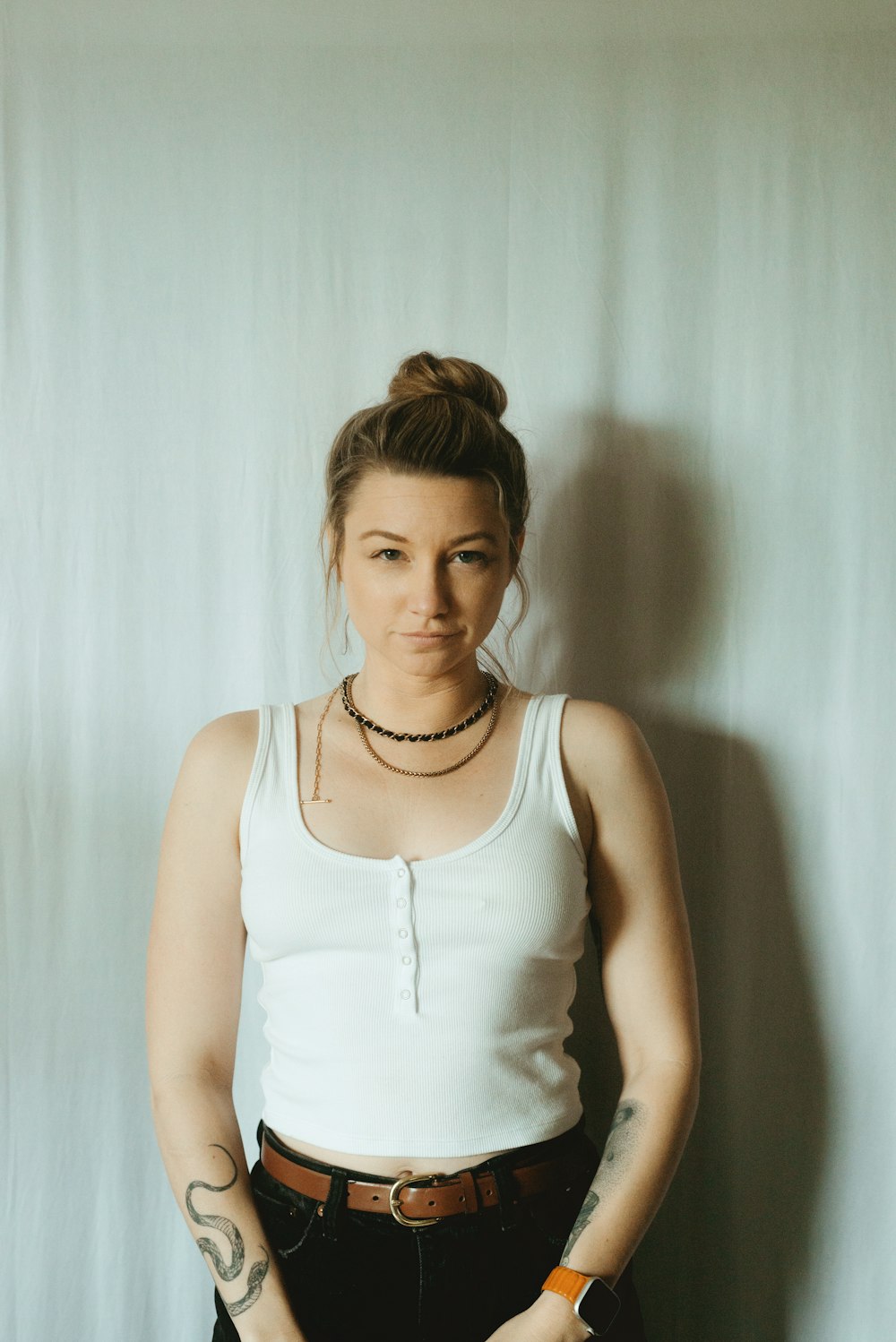 a woman in a white tank top and black pants