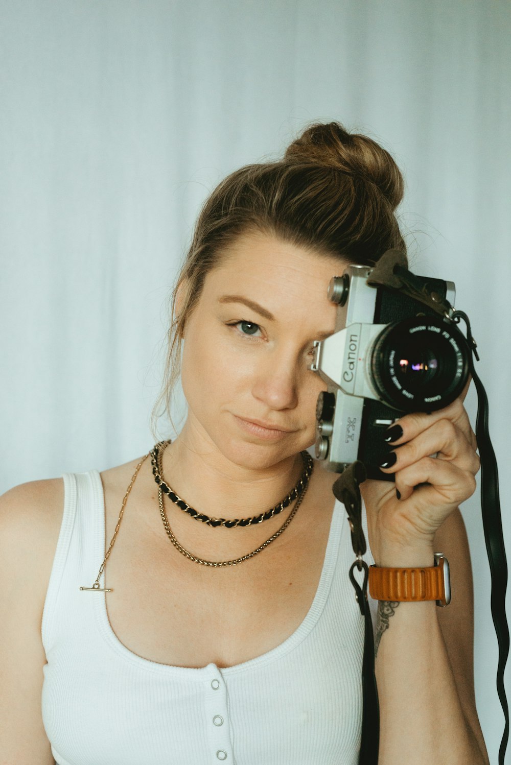 a woman holding a camera up to her face