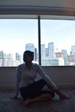 A peaceful setting showing a trader practicing mindful breathing exercises near a window at dawn.