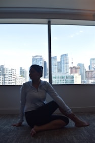 A peaceful setting showing a trader practicing mindful breathing exercises near a window at dawn.