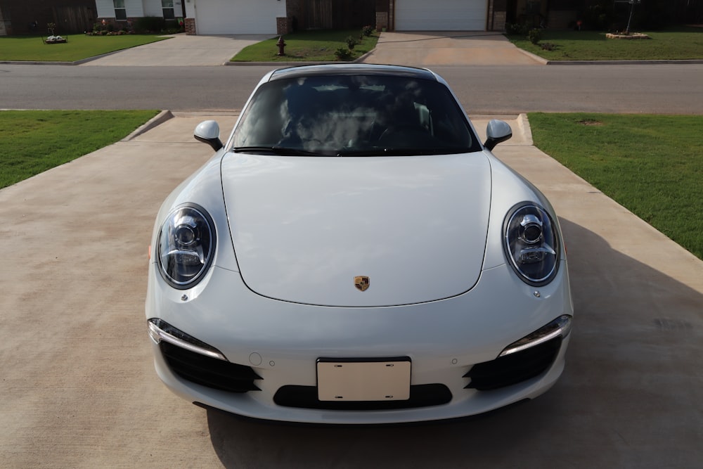 a white sports car parked in a driveway