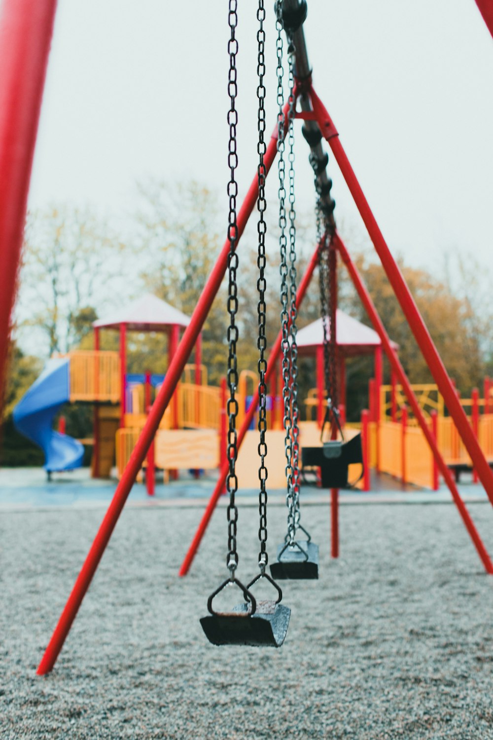 a playground with swings and swings in the background