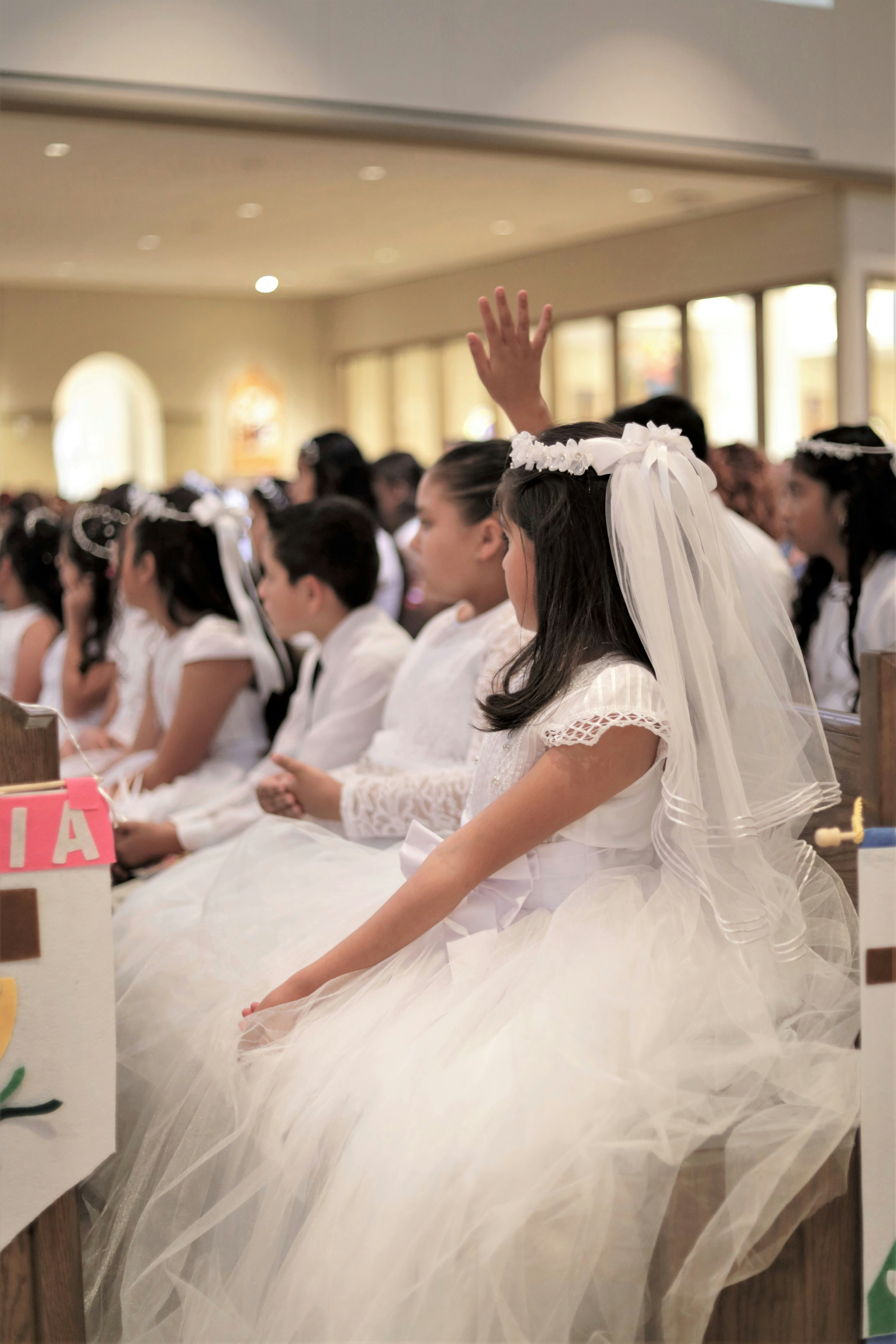 a group of people in white dresses sitting down