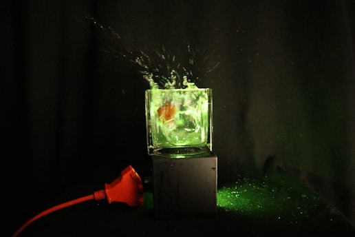 A futuristic cleaning product dissolving in water with a green glow.