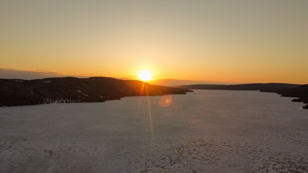 the sun is setting over a large body of water