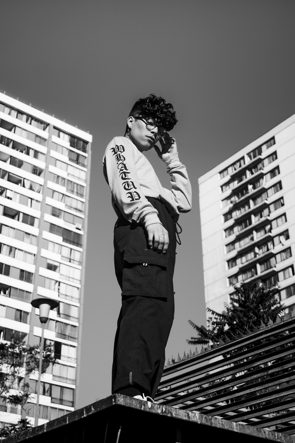 a man standing on top of a roof talking on a cell phone