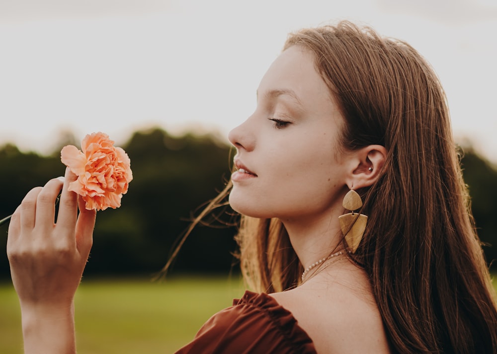 a woman holding a flower in her right hand