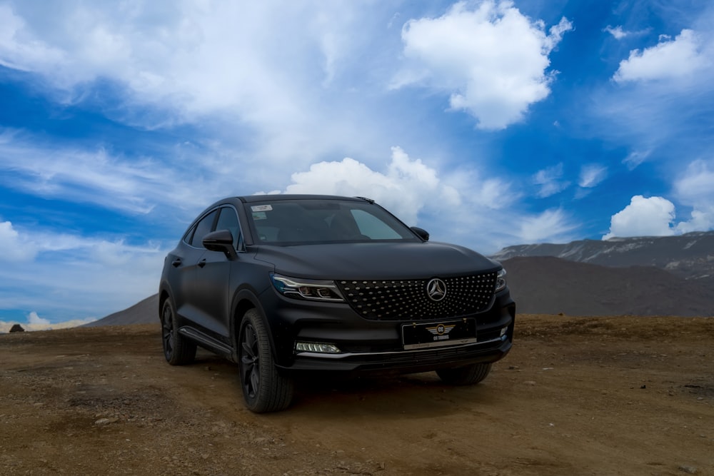 a black car parked on a dirt road