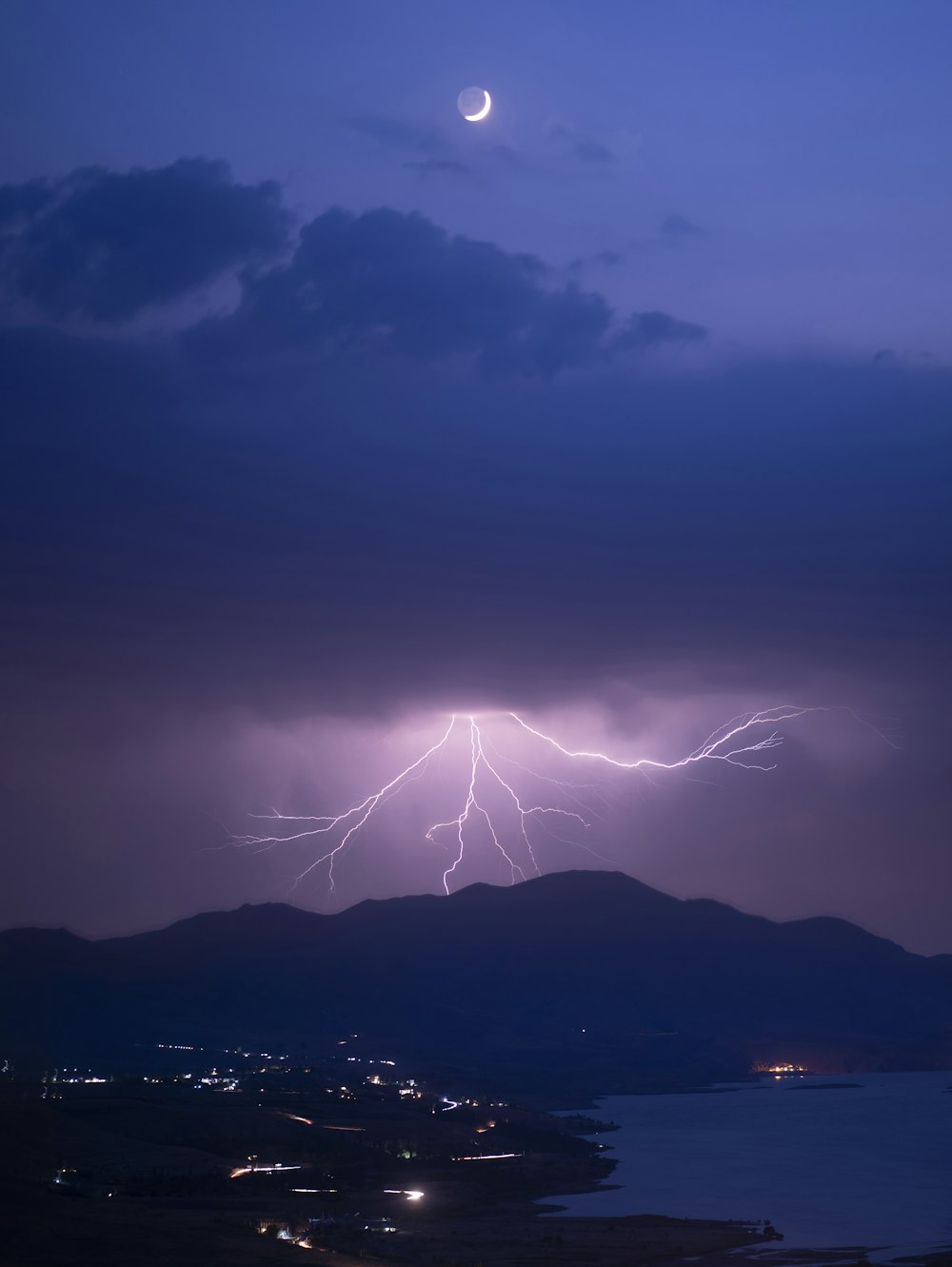 a lightning bolt hitting over a city at night