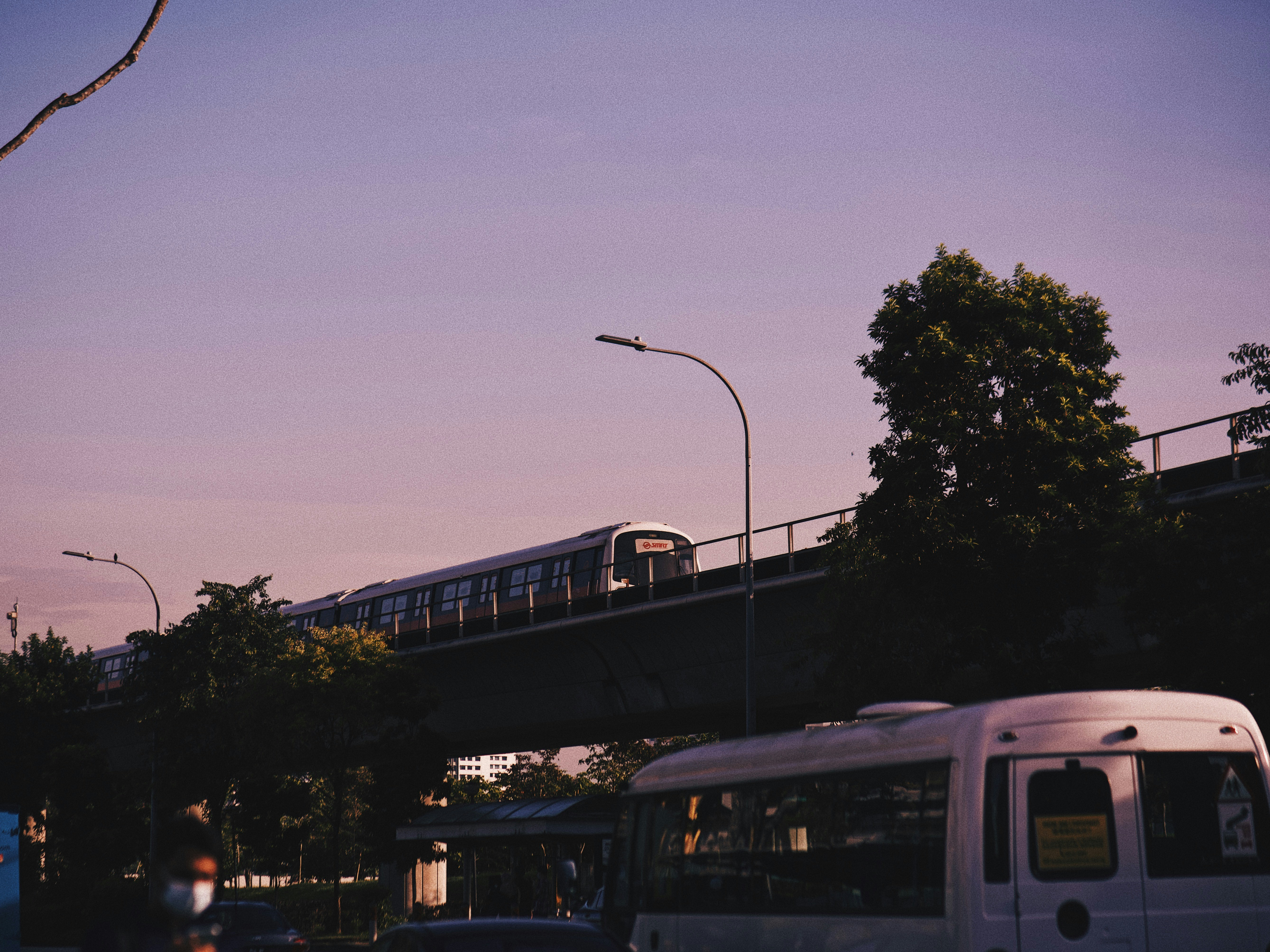 a white van driving down a street next to a bridge