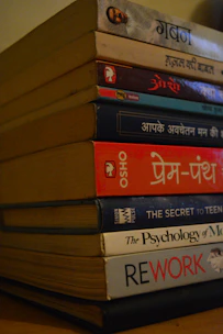a stack of books sitting on top of a wooden table