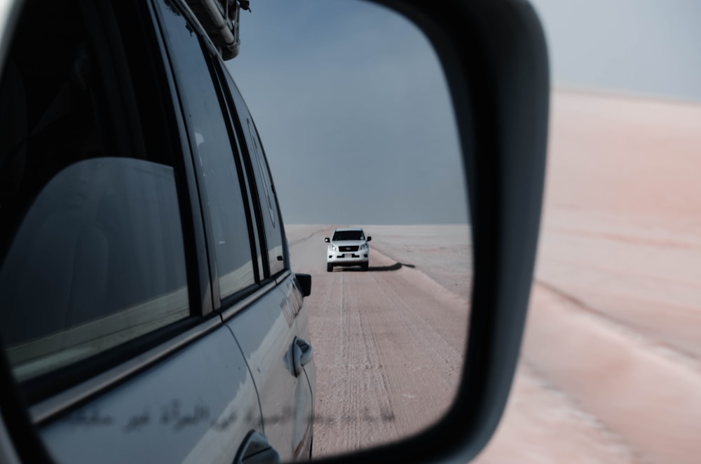 a car is seen in the side mirror of a vehicle