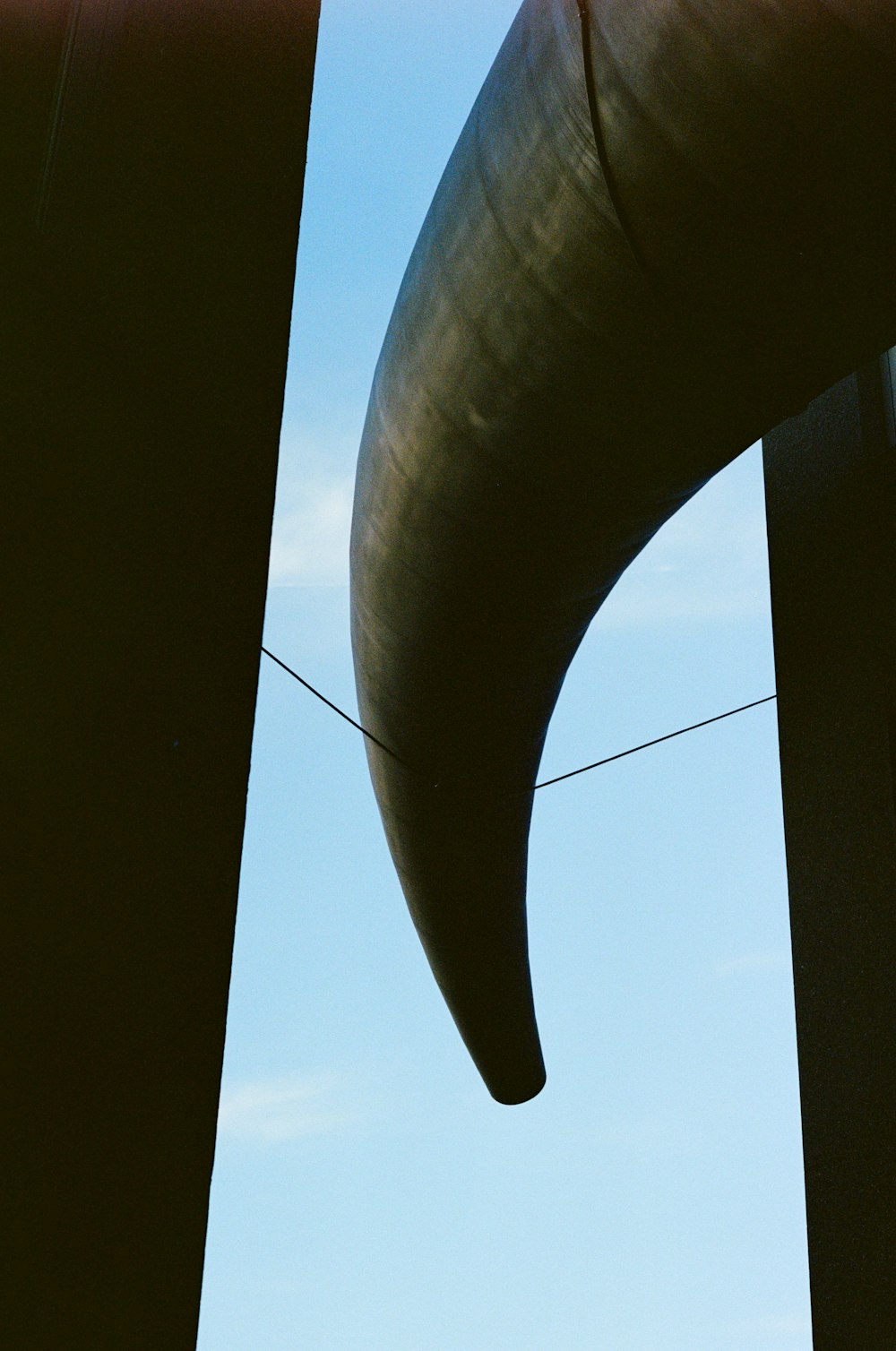a close up of a metal object with a sky background