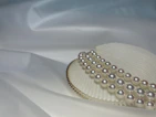 Pearl strands being carefully inspected by a skilled artisan.