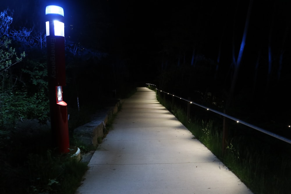 a walkway lit up at night with a street light
