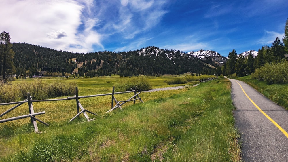 a wooden fence sitting next to a lush green field