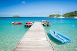 three boats are docked at the end of a pier