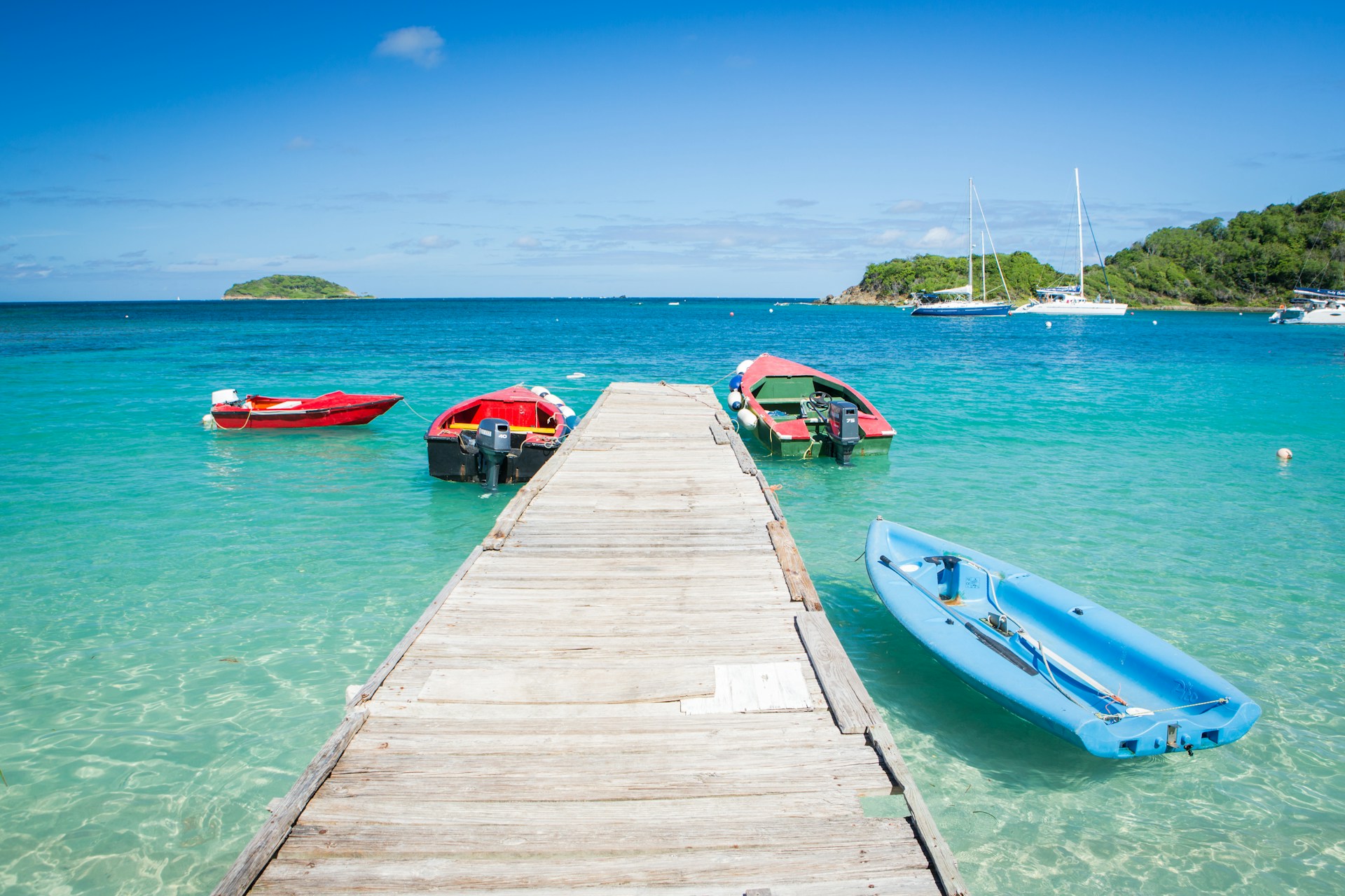 three boats are docked at the end of a pier