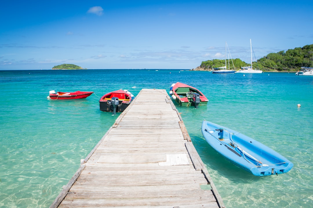 three boats are docked at the end of a pier, A small dock on a Caribbean island.