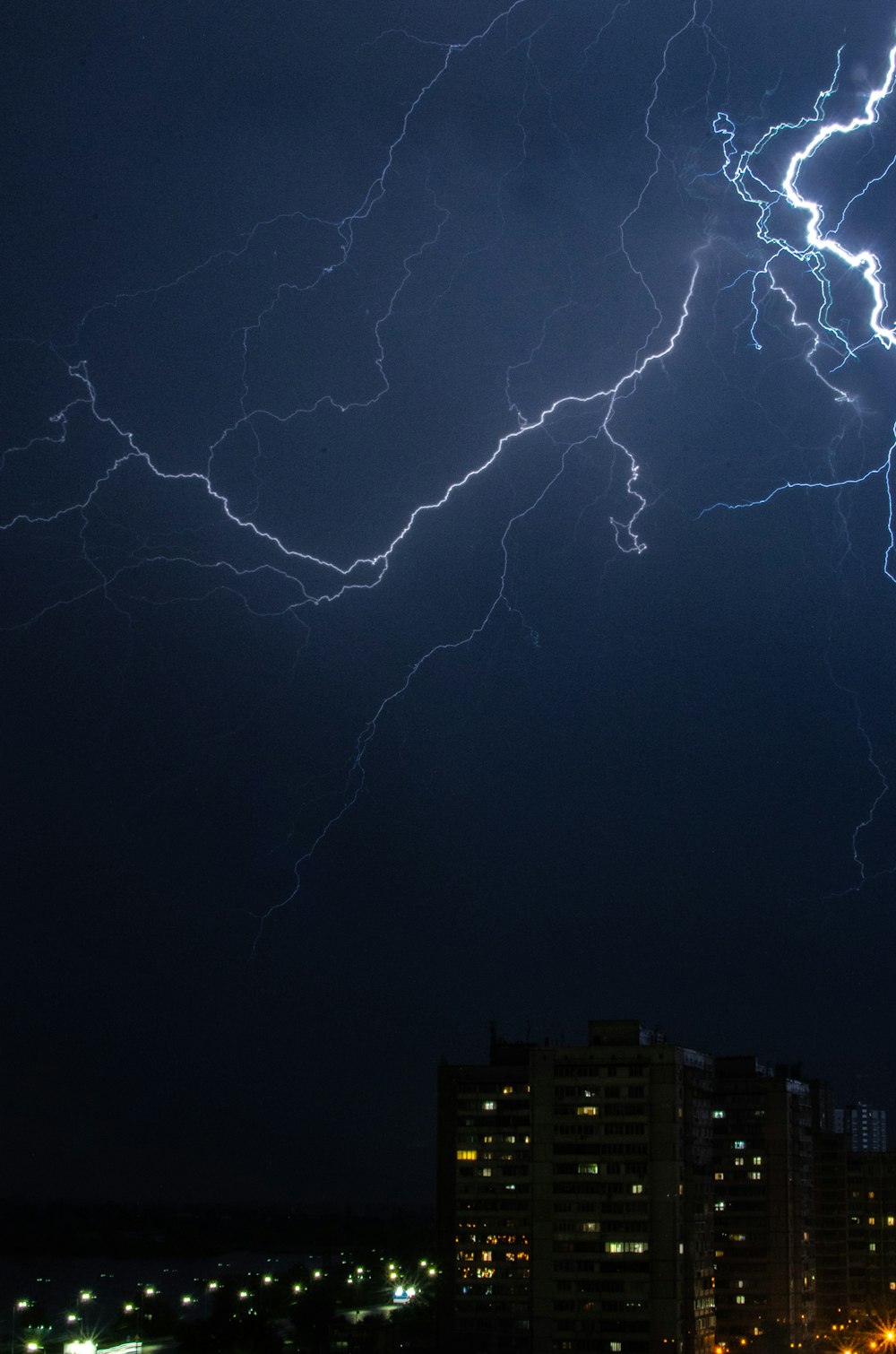 a lightning bolt strikes over a city at night