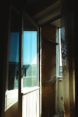 Close-up of a balcony secured with protective mesh, sunlight filtering through.