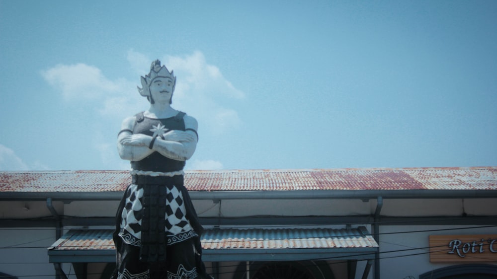 a statue of a man wearing a costume stands in front of a building