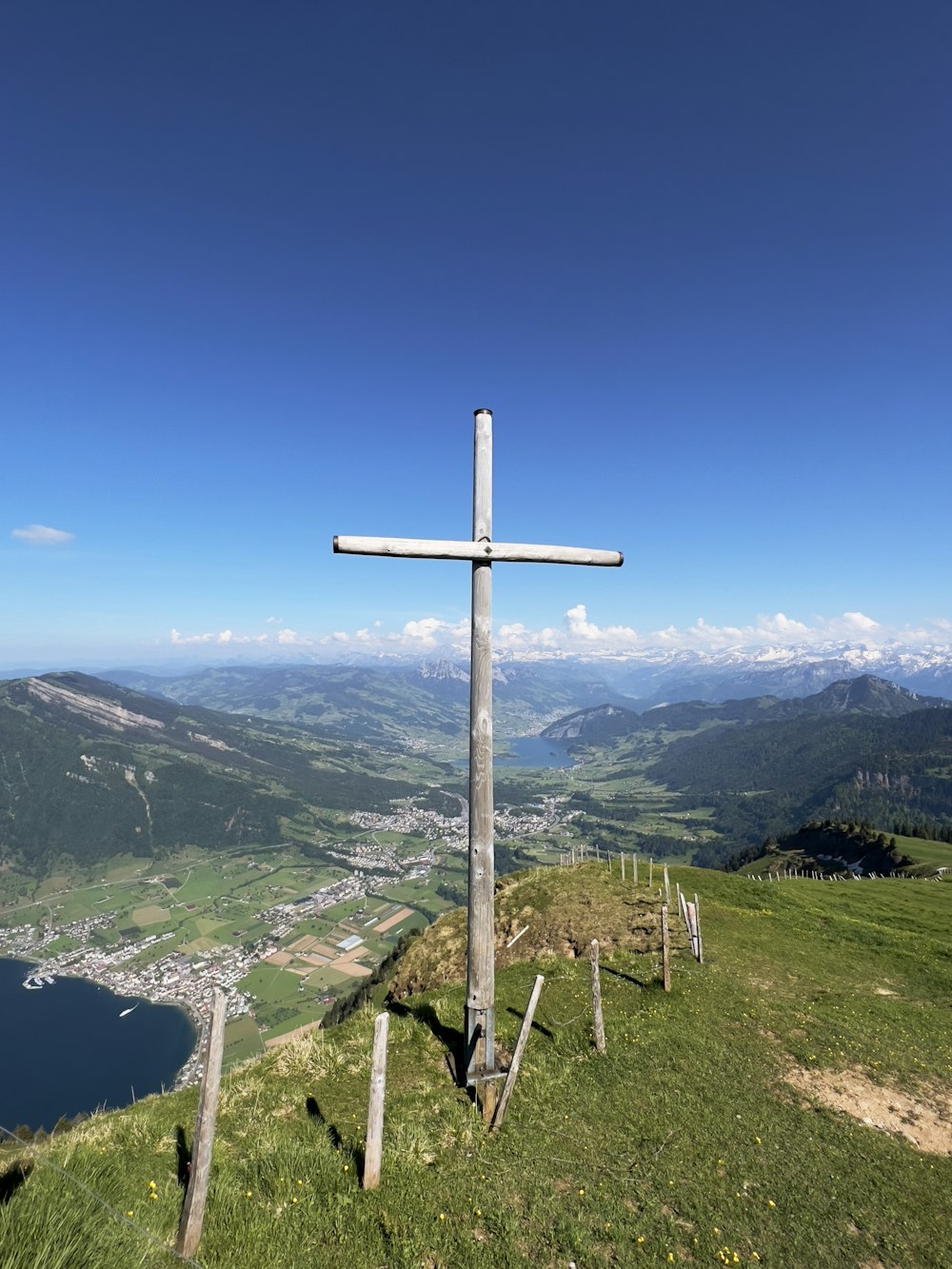 a cross on top of a hill with a lake in the background