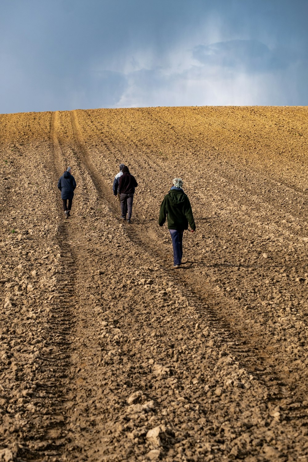 a group of people walking across a dirt field