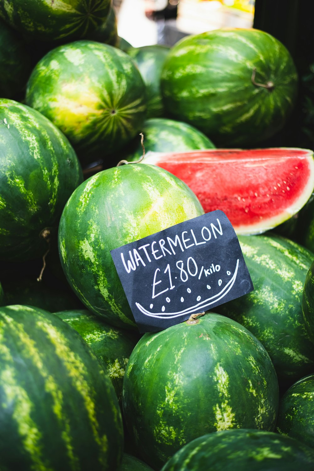 a pile of watermelons for sale at a market