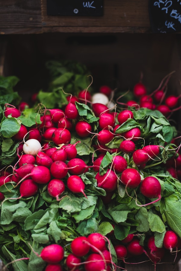 A pile of radishes sitting on top of green leaves