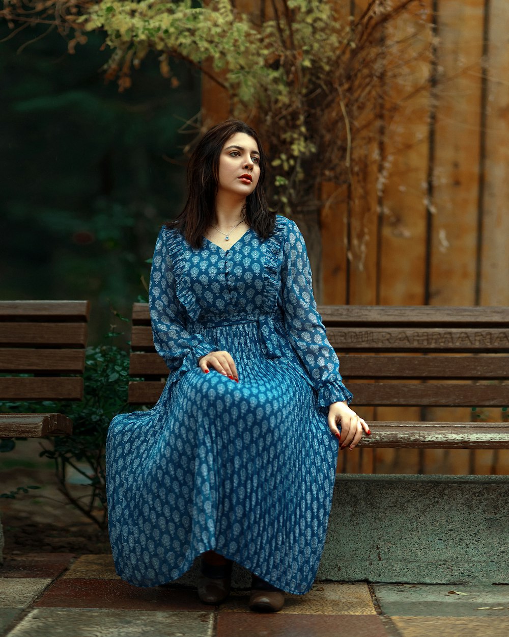 ベンチに座っている青いドレスを着た女性