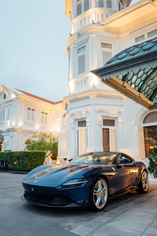 a blue sports car parked in front of a building