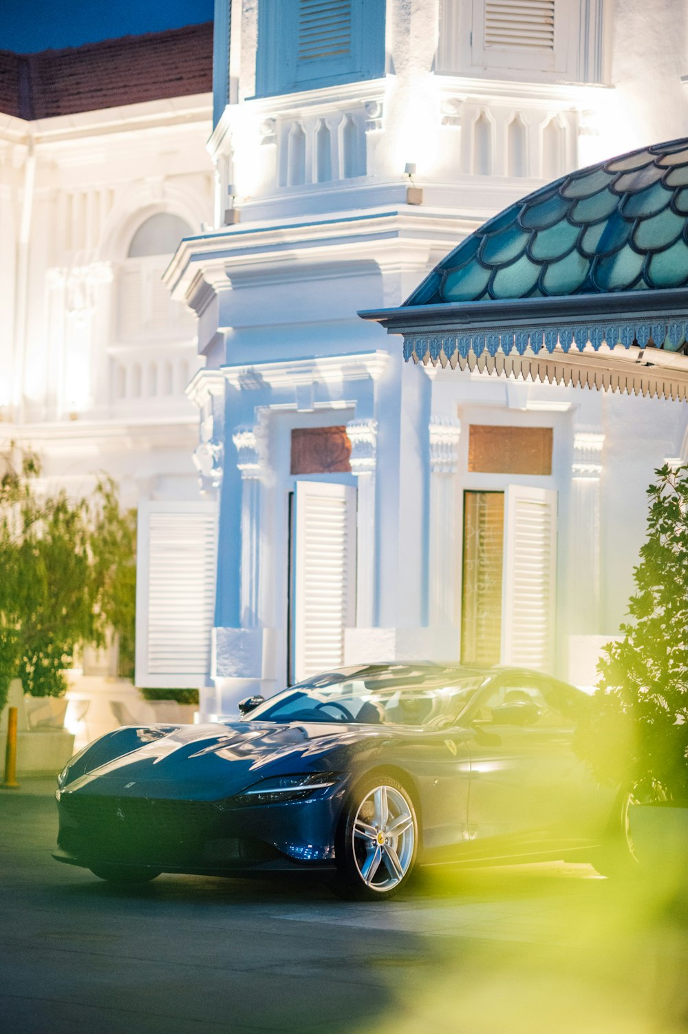 a blue sports car parked in front of a white building